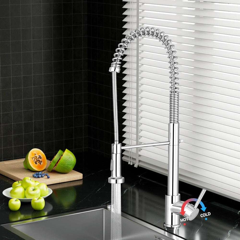 Polished chrome pull-down kitchen mixer tap over a stainless sink