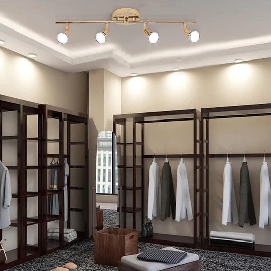 Gold four head LED track lighting bar mounted on a hallway ceiling