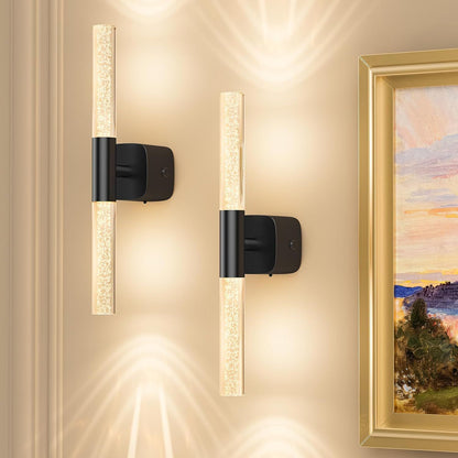 Pair of gold and crystal battery wall sconces lit on a bedroom wall