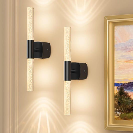 Pair of gold and crystal battery wall sconces lit on a bedroom wall