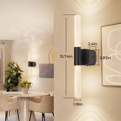 Pair of gold and crystal battery wall sconces lit on a bedroom wall