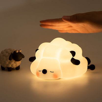 Soft rubber sheep night light glowing warm white on a bedside surface