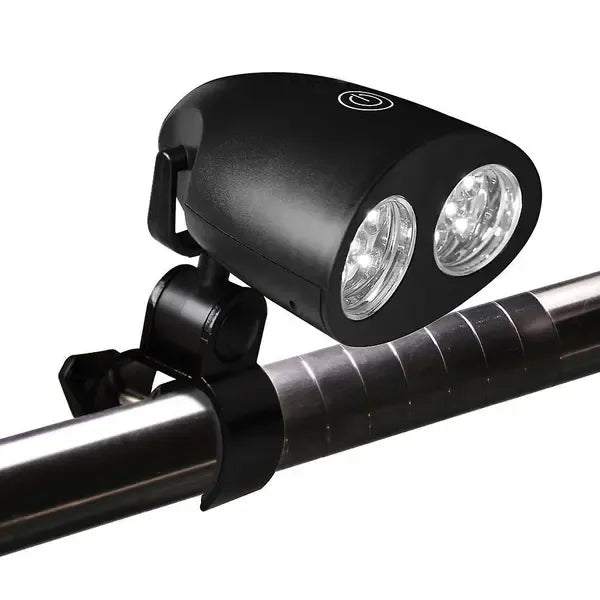 Black clip-on LED grill light clamped to a barbecue handle at night