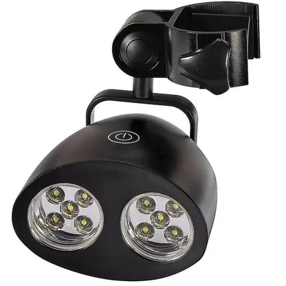 Black clip-on LED grill light clamped to a barbecue handle at night