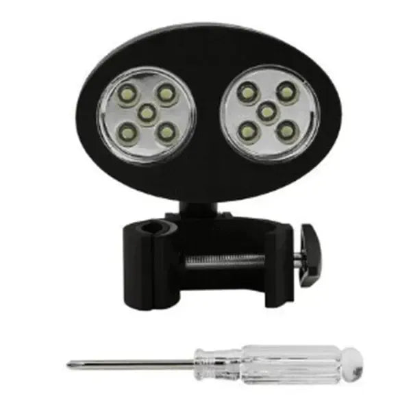 Black clip-on LED grill light clamped to a barbecue handle at night