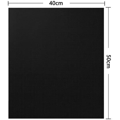 Three black non-stick barbecue grill mats with food cooking on one