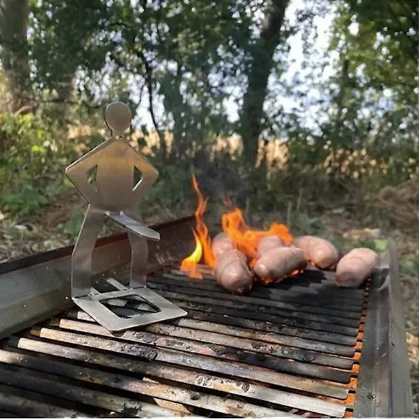 Six stainless steel standing sausage holders on a barbecue grill