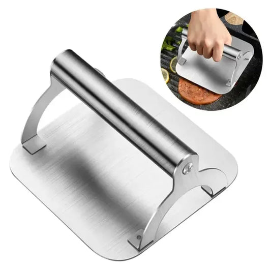 Square stainless steel burger press with round handle on a hot flat top
