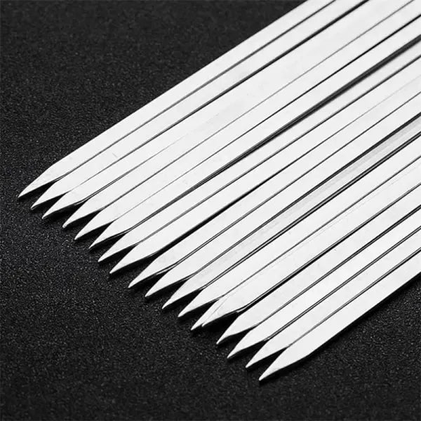 Ten flat-bladed stainless steel barbecue skewers laid out in a row