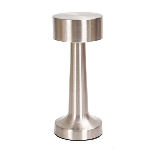 Silver dumbbell-shaped rechargeable desk lamp lit on a desk