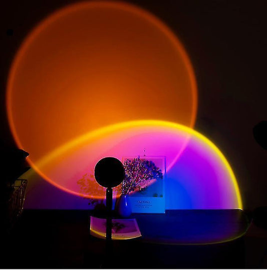 Rotating projection lamp casting a warm sunset glow across a bedroom wall