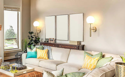 Pair of gold metal wall sconces with fabric shades lit on a wall