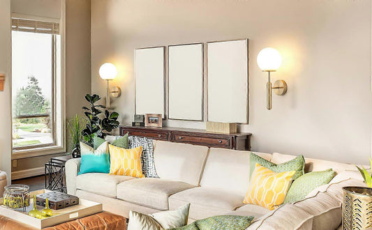 Pair of gold metal wall sconces with fabric shades lit on a wall