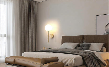 Pair of gold metal wall sconces with fabric shades lit on a wall