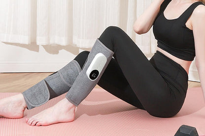 Grey heated leg massager with wraparound design and hook and loop closure