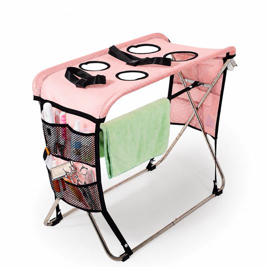 Pink foldable pet grooming table with mesh top, restraint strap and towel bar
