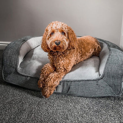 Pink orthopaedic pet sofa bed with bolstered edges and a removable cover