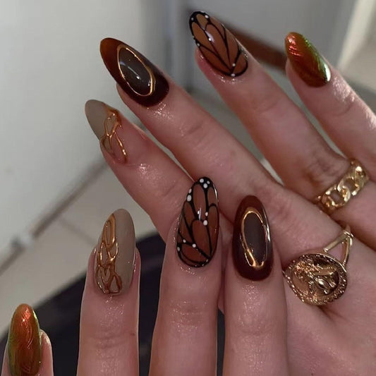 Brown medium almond press-on nails with butterfly wing designs and chrome accents