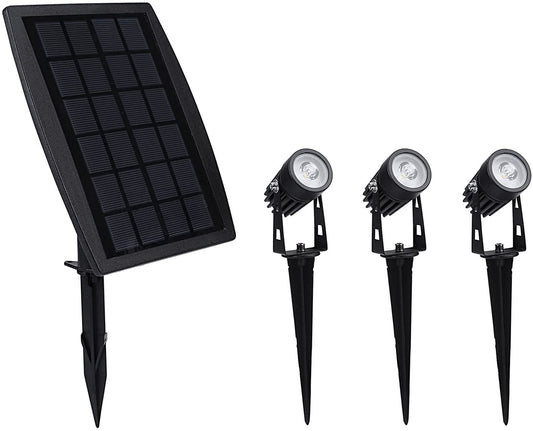 Black aluminium solar garden spotlight uplighting a tree at dusk