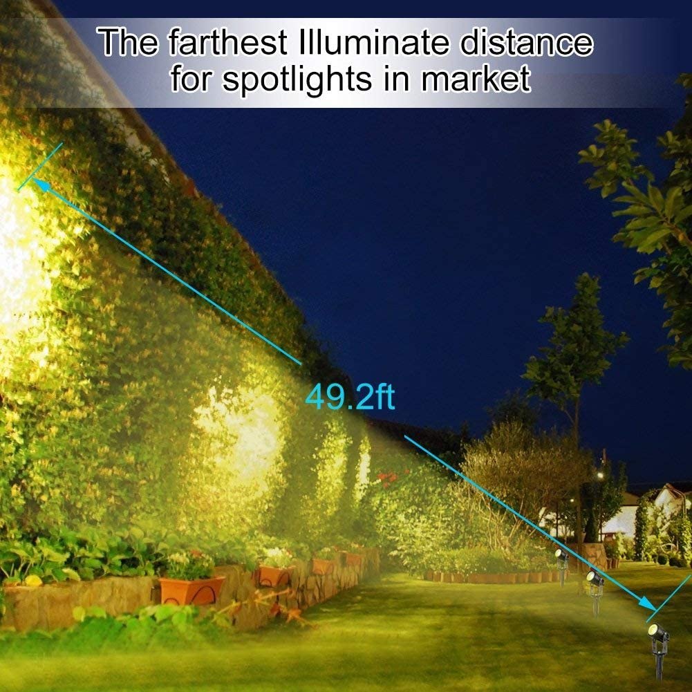 Black aluminium solar garden spotlight uplighting a tree at dusk