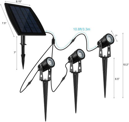 Black aluminium solar garden spotlight uplighting a tree at dusk