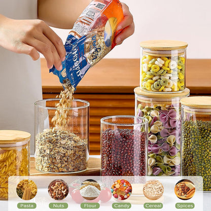 Twelve clear glass storage jars with bamboo lids in assorted sizes for pantry organisation