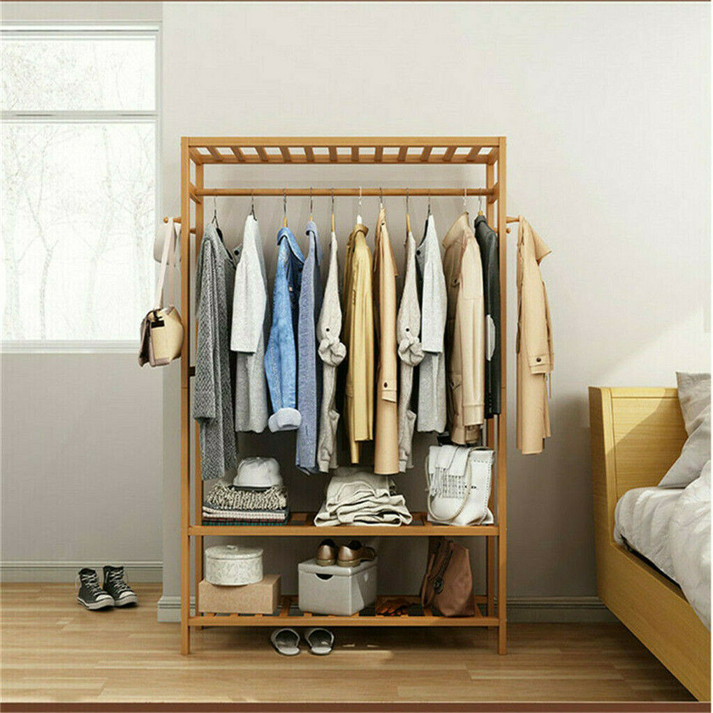 Three-tier bamboo clothes rack on wheels with side hooks and shelves