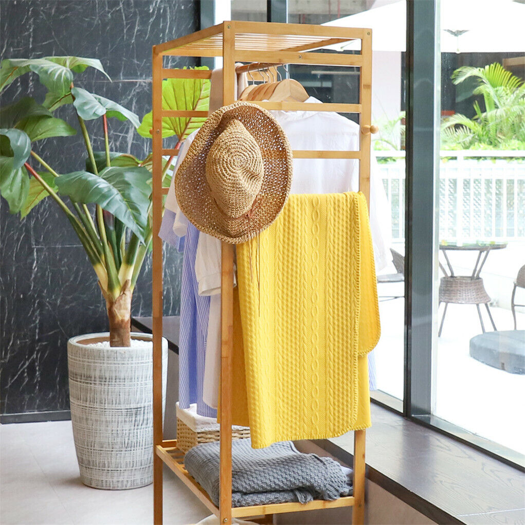 Three-tier bamboo clothes rack on wheels with side hooks and shelves