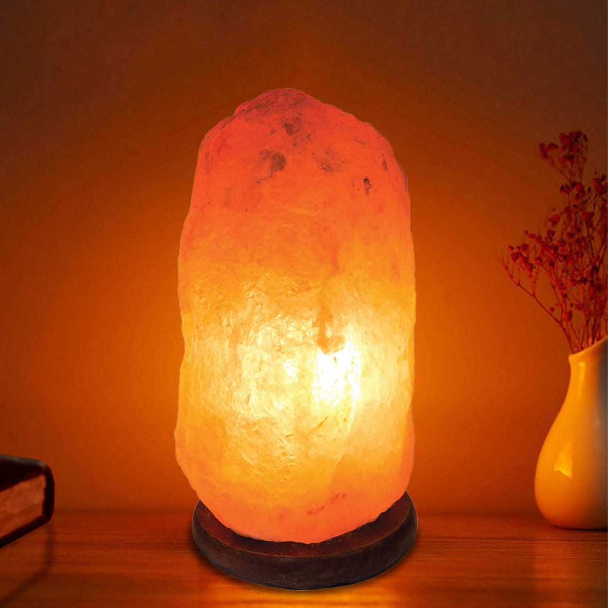 Natural pink Himalayan salt lamp on a wooden base with clear bulb