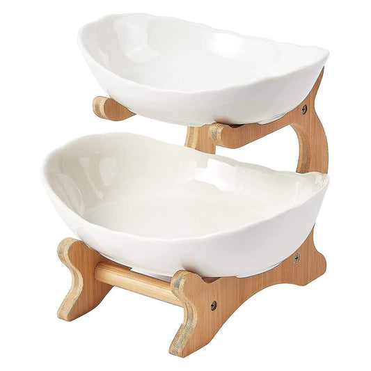 Two tier porcelain fruit bowl stand on a bamboo frame holding fruit