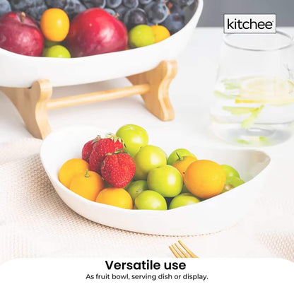 Two tier porcelain fruit bowl stand on a bamboo frame holding fruit