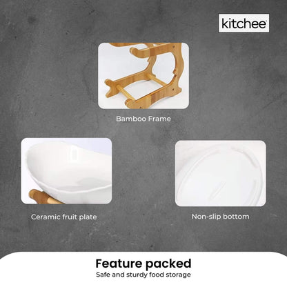 Two tier porcelain fruit bowl stand on a bamboo frame holding fruit