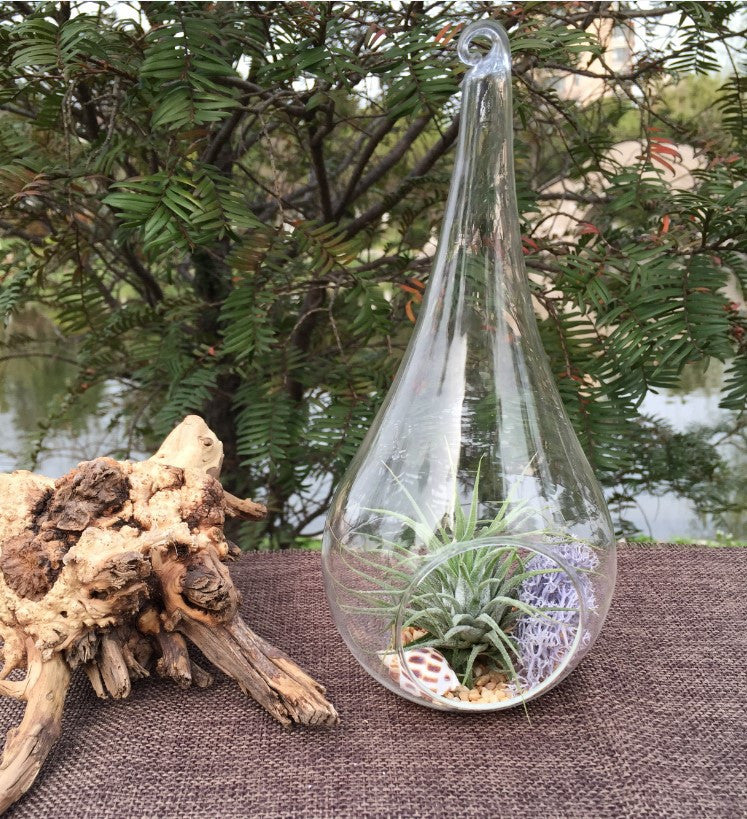 Clear glass teardrop tealight holders hanging at different heights