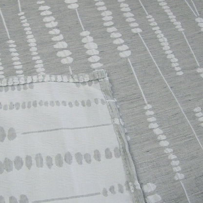 Grey and white jacquard polyester tablecloth laid over a rectangular dining table