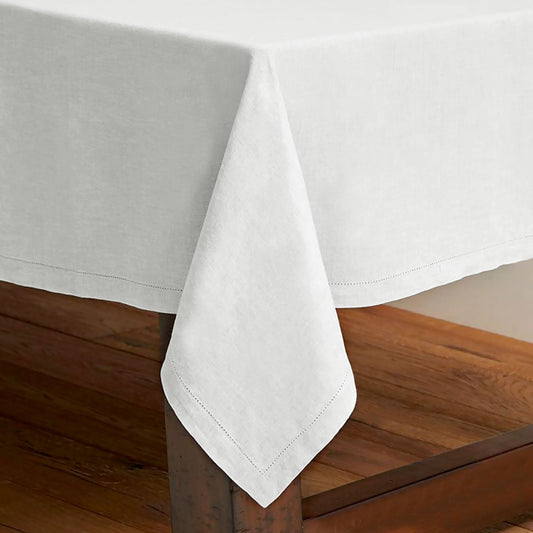 White pure cotton hemstitch tablecloth laid over a long dining table