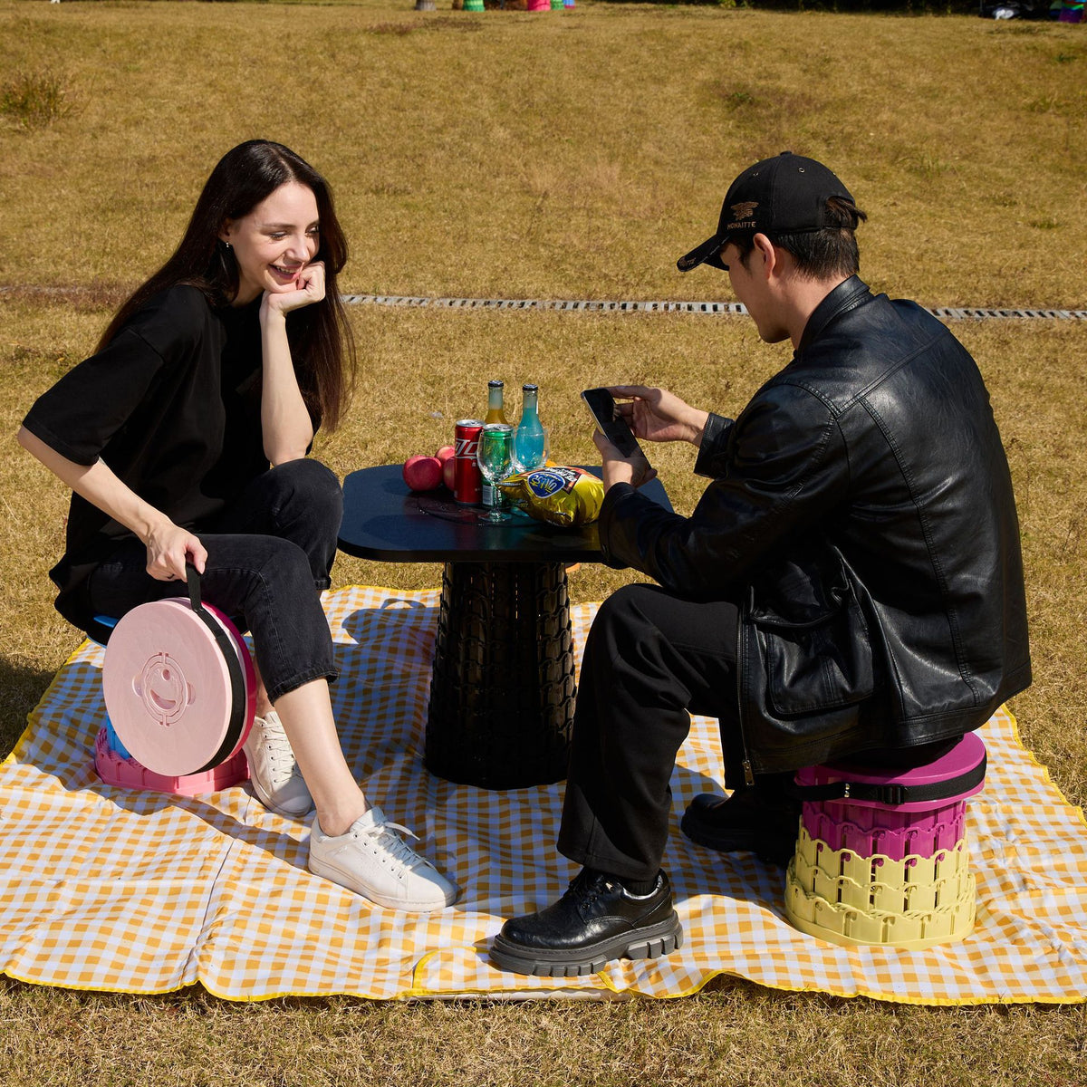Green telescopic camping stool with wide round seat and carry strap