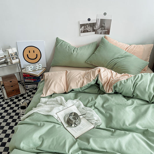 Washed cotton bedding set in light green and camel made up on a bed