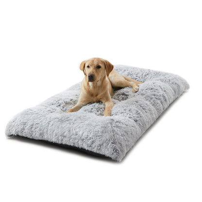 Thick grey plush winter dog bed with long faux fur on a timber floor