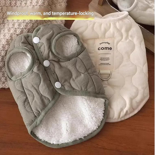 Beige quilted dog vest with leash ring beside a coffee-coloured oval fleece pet bed