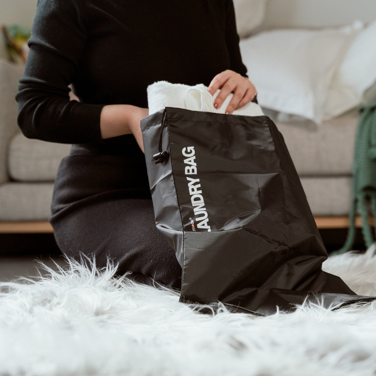 Eight black drawstring laundry bags arranged together