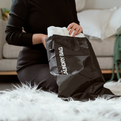 Eight black drawstring laundry bags arranged together