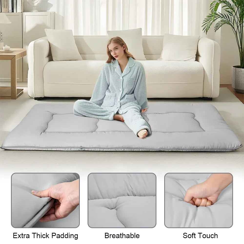 Grey foldable futon mattress with a smooth polyester cover for floor sleeping