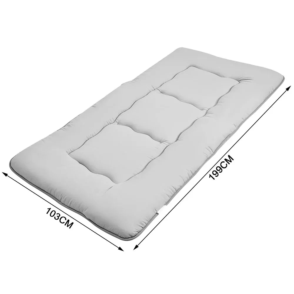 Grey foldable futon mattress with a smooth polyester cover for floor sleeping